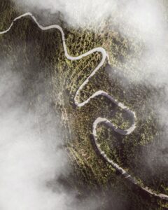 Aerial shot of roads winding through a hill, with clouds above
