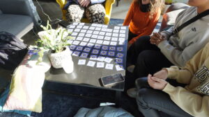 Íslenska: Fjórir unglingar spila minnisspil með Eurodesk-myndum á borði. English: Four teens play a memory game with Eurodesk-themed cards on a coffee table.